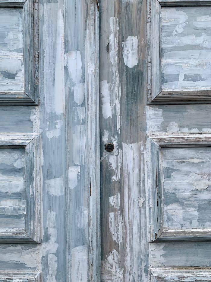 Detailed view of an aged wooden door undergoing restoration, showcasing vintage charm.