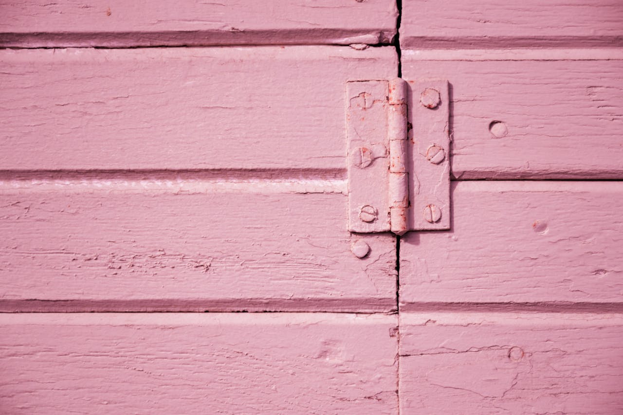 A detailed shot of a pink wooden hinge showcasing texture and color contrast.