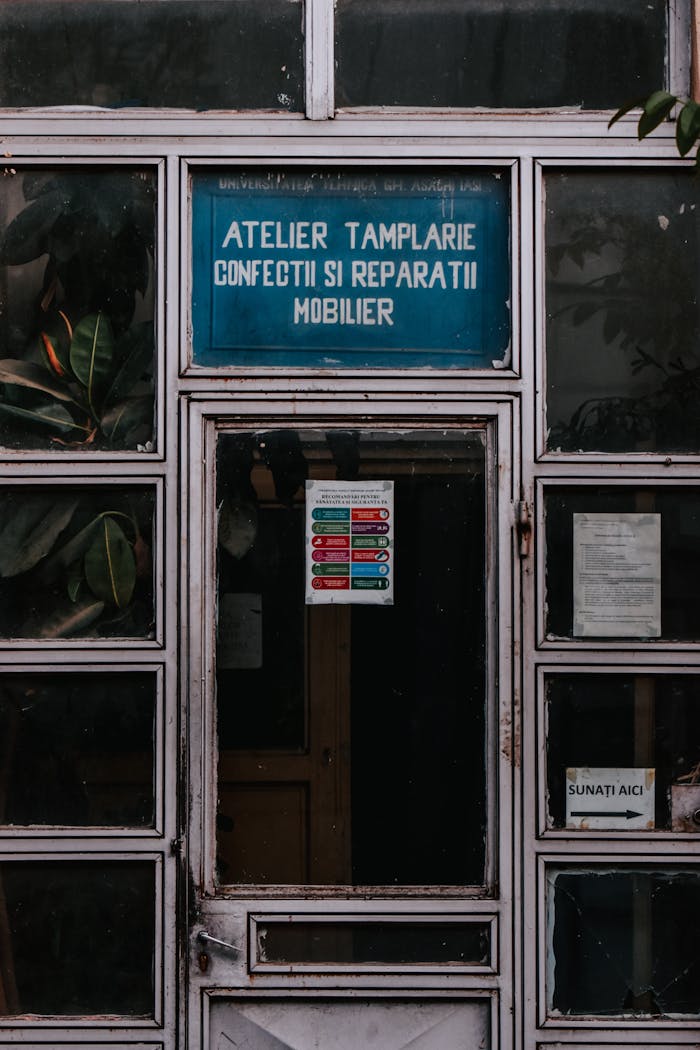 Old workshop entrance with detailed signage and worn wooden doors.